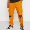 Karl Kani SIGNATURE CRINCLE PANTS UNISEX - Cargohose - Orange 1 Karl Kani SIGNATURE CRINCLE PANTS UNISEX - Cargohose - Orange -Outlet KARL KANI Store 315005373928440491f04149ff41f5d5
