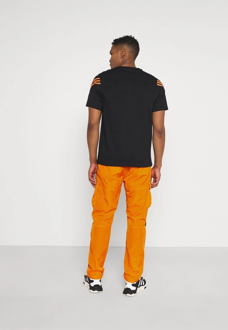 SIGNATURE CRINCLE PANTS UNISEX - Cargohose - orange Karl Kani SIGNATURE CRINCLE PANTS UNISEX - Cargohose - Orange -Outlet KARL KANI Store 8fdbb43b41074a31a267a20a3406541e