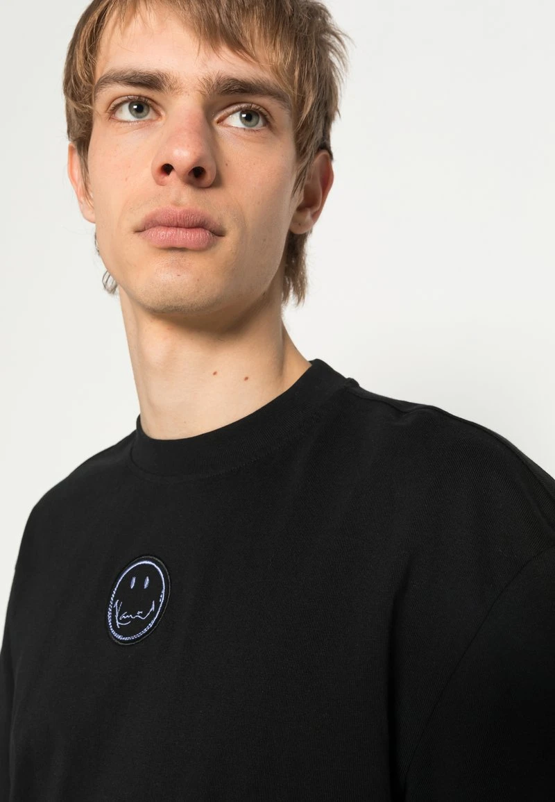 KARL KANI X SMILEY® SMALL SIGNATURE PRINT TEE - T-Shirt Print - Black, Unisex 7 KARL KANI X SMILEY® SMALL SIGNATURE PRINT TEE - T-Shirt Print - Black, Unisex – Bild 5